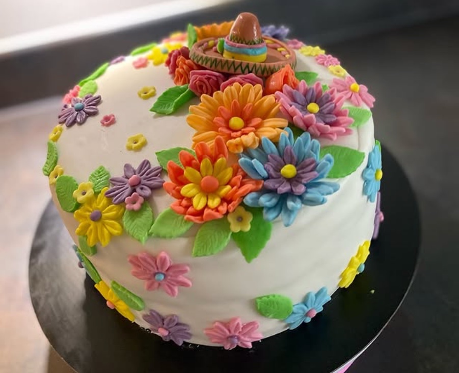Bolo decorado com flores coloridas e sombreiro mexicano
